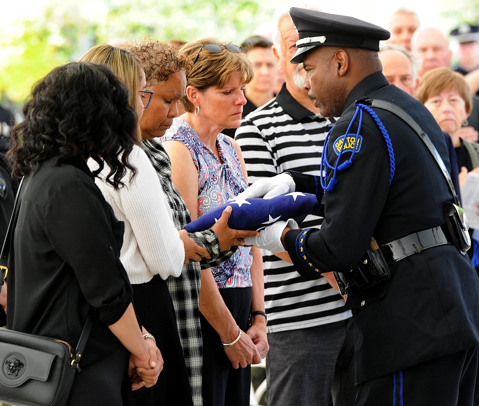 A member of the Dayton Police Department Honor Guard places a folded American in the hands of the DelRio family during the Montgomery County 14th Annual Law Enforcement Memorial CermonyMonday, Sept. 27, 2021. MARSHALL GORBY\STAFF