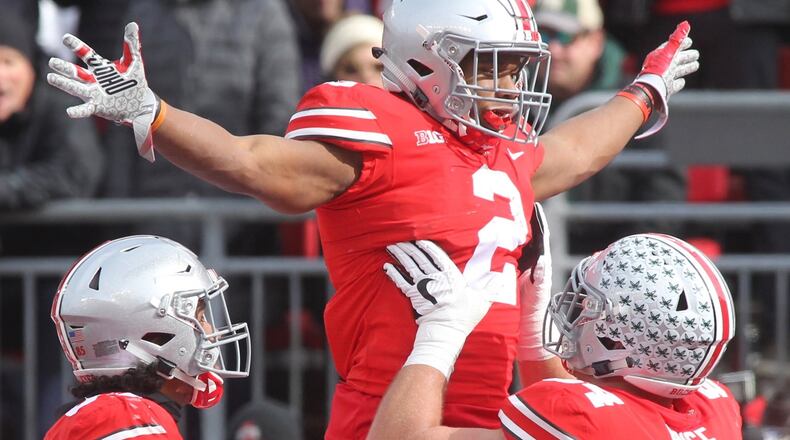 Ohio State’s Billy Price lifts J.K. Dobbins after a touchdown against Michigan State on Saturday at Ohio Stadium in Columbus. On the Buckeyes’ first score, a 47-yard burst up the middle by running back Mike Weber, Price had two key blocks. DAVID JABLONSKI / STAFF