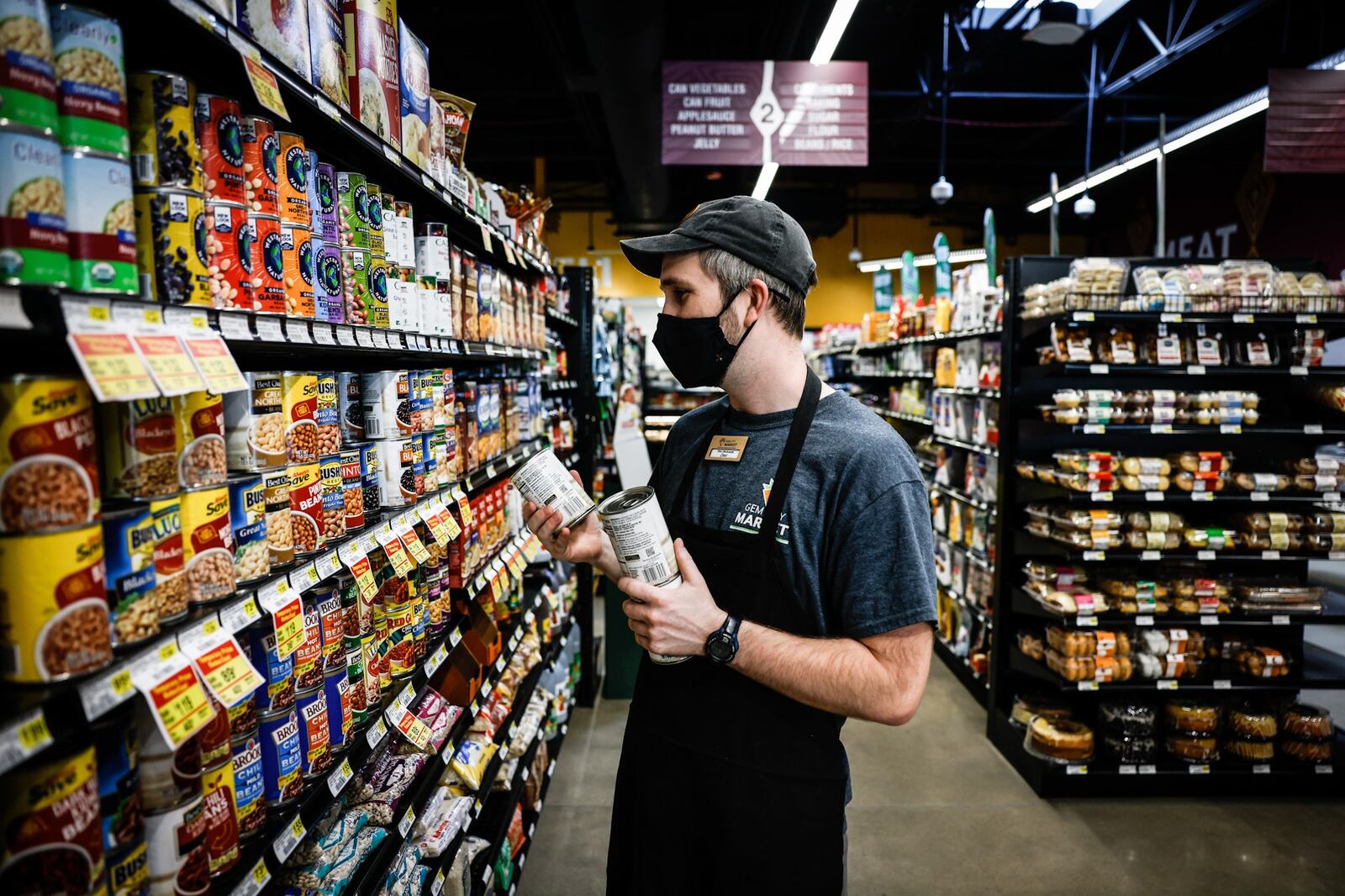 Gem City Market Deli Manager, Chris Bender, grabs cans for the lunch salad bar at the market on Tuesday May 10. 2022. This Saturday May 14, Gem City Market will hold a celebration of it's first year anniversary. JIM NOELKER/STAFF