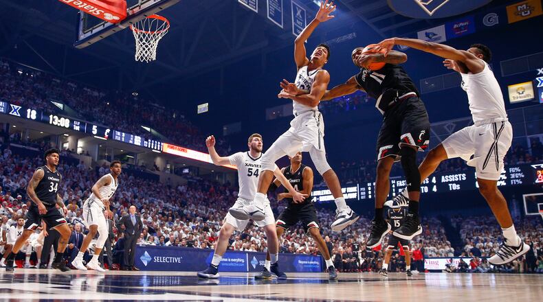CINCINNATI, OH - DECEMBER 02: Gary Clark #11 of the Cincinnati Bearcats looks to keep the ball as Kaiser Gates #22 and Paul Scruggs #1 of the Xavier Musketeers defends at Cintas Center on December 2, 2017 in Cincinnati, Ohio. (Photo by Michael Hickey/Getty Images)