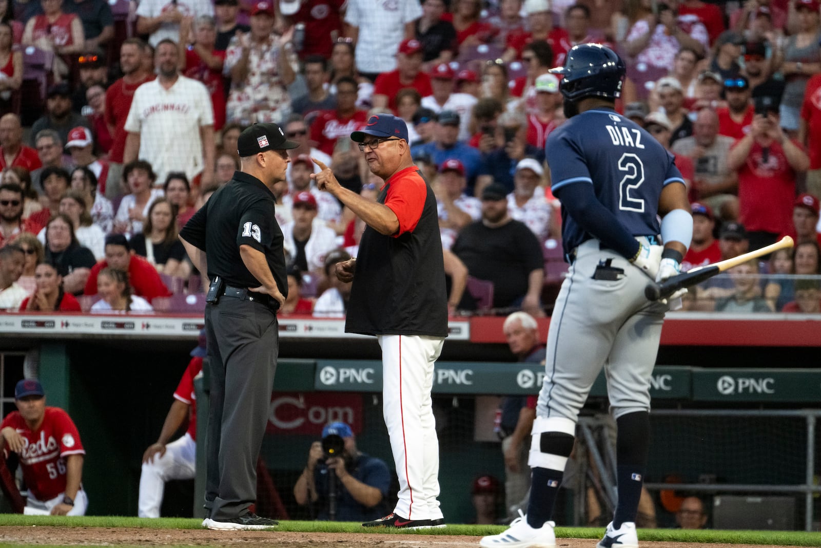 Cincinnati Reds head coach Terry Francona, center, yells at an official, left, in the seventh inning against the Tampa Bay Rays, Saturday July 26, 2025, in Cincinnati. (AP Photo/Michael Swensen)