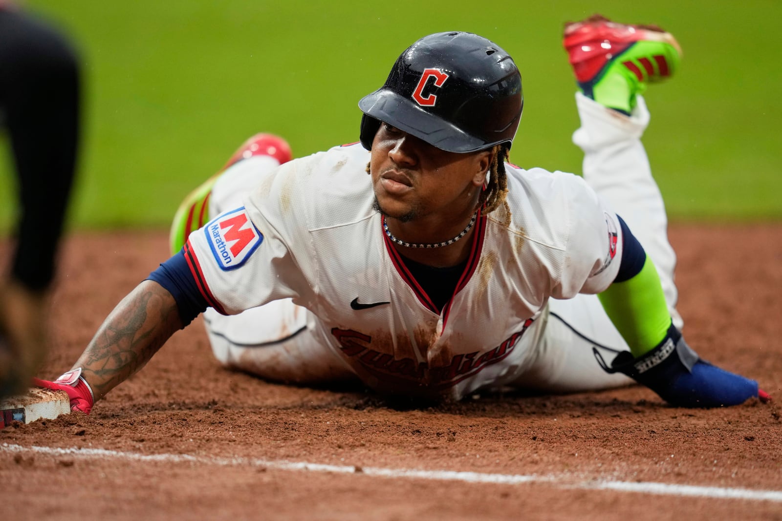 Cleveland Guardians' Jose Ramirez dives back into first base on a pickoff-attempt in the tenth inning of a baseball game against the Minnesota Twins in Cleveland, Thursday, May 1, 2025. (AP Photo/Sue Ogrocki)