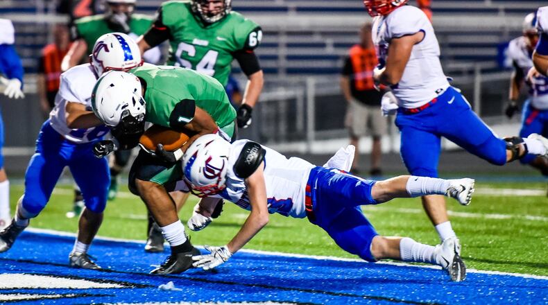 Badin’s Davon Starks punches the ball into the end zone for a touchdown during Friday night’s game against Carroll at Hamilton’s Virgil Schwarm Stadium. NICK GRAHAM/STAFF
