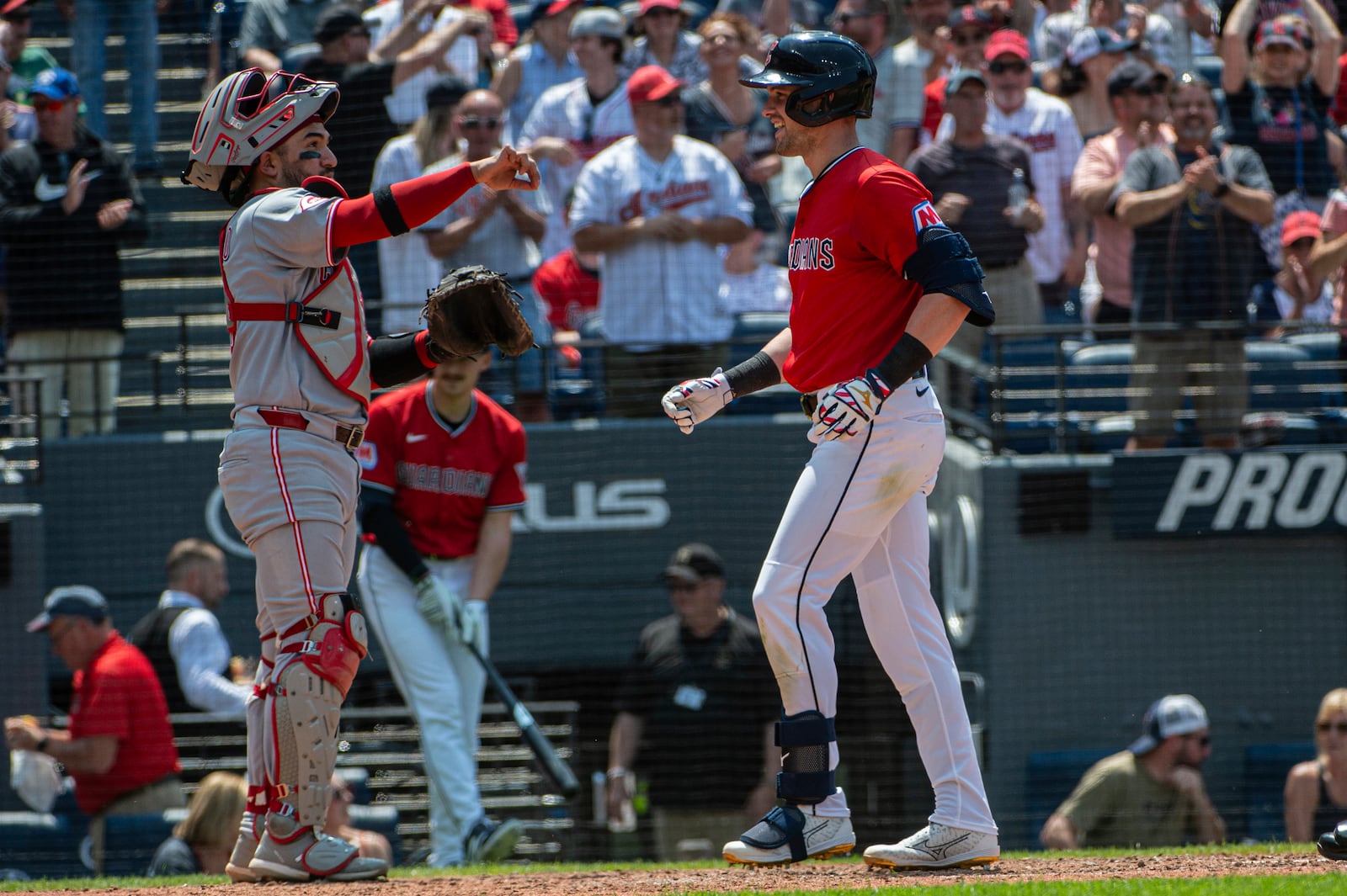 Cleveland Guardians' Lane Thomas, right, touches home plate after hitting a three-run home run off Cincinnati Reds relief pitcher Joe La Sorsa as Jose Trevino stands by during the sixth inning of a baseball game, Wednesday, June 11, 2025, in Cleveland. (AP Photo/Phil Long)