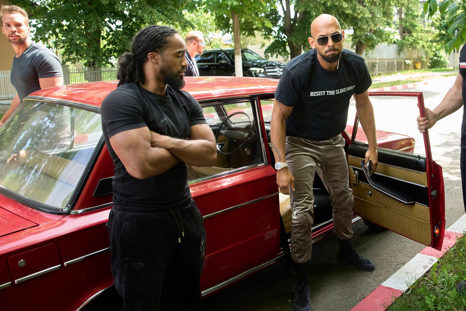 Andrew Tate and his brother Tristan, top left, arrives at a police station in a Lada vehicle in Voluntari, Romania, Wednesday, May 21, 2025. (AP Photo/Vadim Ghirda)