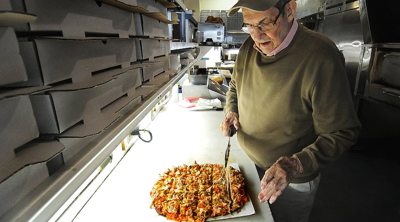 Ron Holp cuts a pizza fresh from the oven at Ron's Pizza in downtown Miamisburg Thursday, Jan. 5, 2023. Holp died Sunday, Nov. 3. MARSHALL GORBY/STAFF