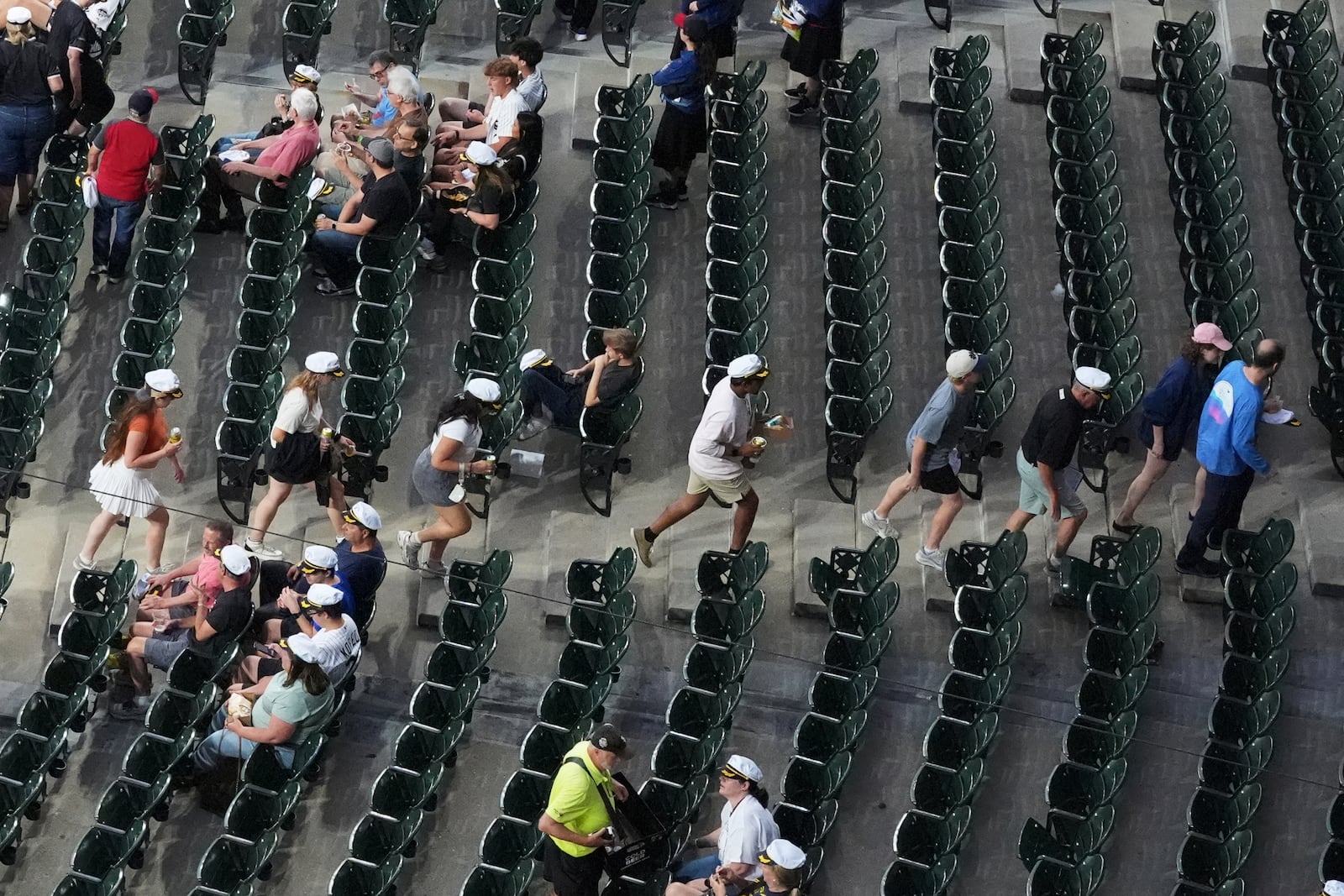 Baseball fans leave and wait during a rain delay before a baseball game between the Cleveland Guardians and the Chicago White Sox in Chicago, Thursday, July 10, 2025. (AP Photo/Nam Y. Huh)