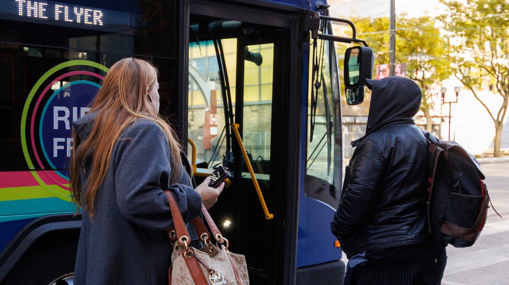 Riders prepare to enter RTA's The Flyer on Monday, Nov. 3 near the RTA hub in downtown Dayton on Main Street. BRYANT BILLING/STAFF