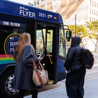 Riders prepare to enter RTA's The Flyer on Monday, Nov. 3 near the RTA hub in downtown Dayton on Main Street. BRYANT BILLING/STAFF