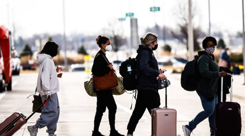 After deplaning at Dayton International Airport, travelers head to their destination Friday March 18, 2022. JIM NOELKER/STAFF