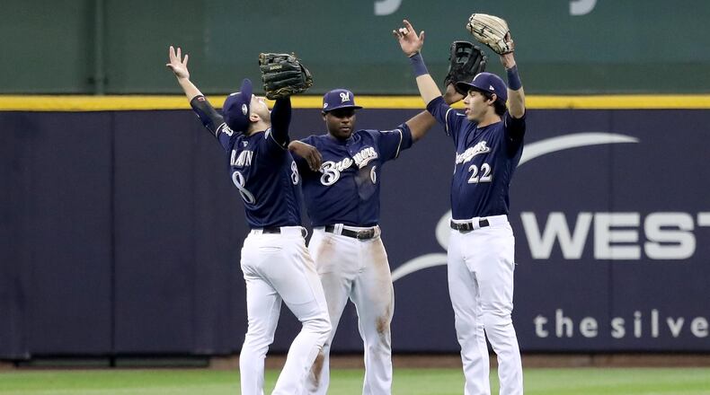 MILWAUKEE, WI - OCTOBER 12:  Ryan Braun #8, Lorenzo Cain #6 and Christian Yelich #22 of the Milwaukee Brewers celebrate after defeating the Los Angeles Dodgers in Game One of the National League Championship Series at Miller Park on October 12, 2018 in Milwaukee, Wisconsin.  (Photo by Rob Carr/Getty Images)