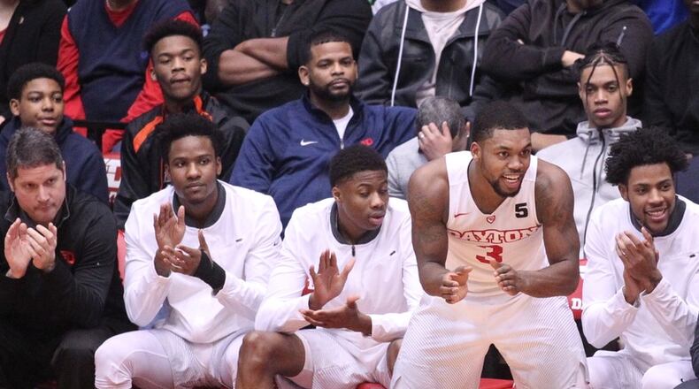 Jhery Matos, second from right in back, watches from behind the Dayton bench as Trey Landers, center, cheers during a game against Fordham on Saturday, Feb. 17, 2018, at UD Arena.