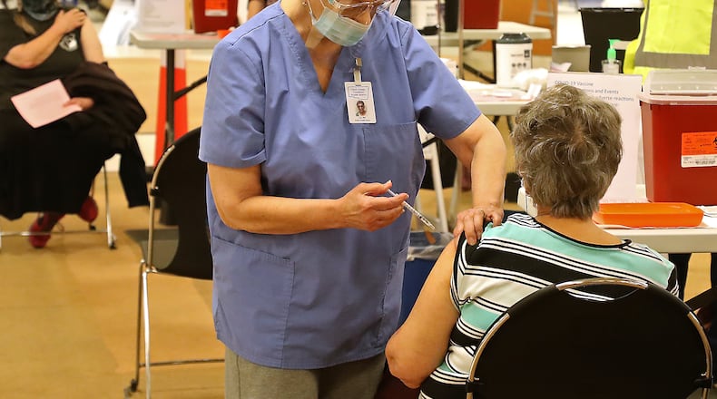 Clark County residents get their COVID vaccine shots at the Clark County Combined Health District's vaccine distribution center at the Upper Valley Mall on Tuesday, Feb. 23. BILL LACKEY/STAFF