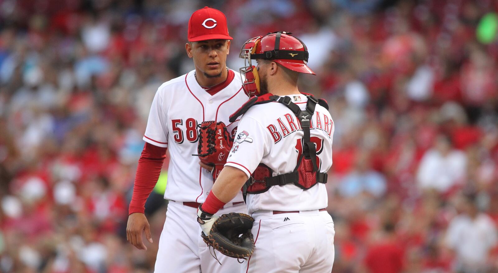 Reds pitcher Luis Castillo talks to catcher Tucker Barnhart during a game in June 2017 against the Brewers at Great American Ball Park in Cincinnati. David Jablonski/Staff