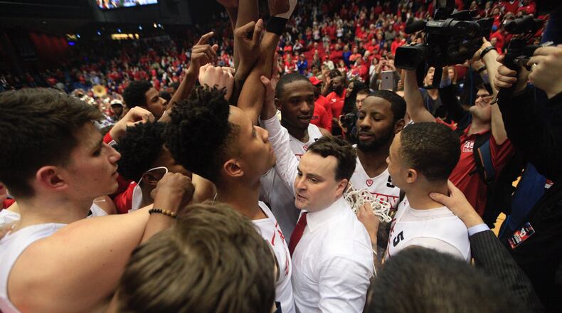 Dayton players huddle around coach Archie Miller after a victory against Virginia Commonwealth on Wednesday, March 1, 2017, at UD Arena. David Jablonski/Staff