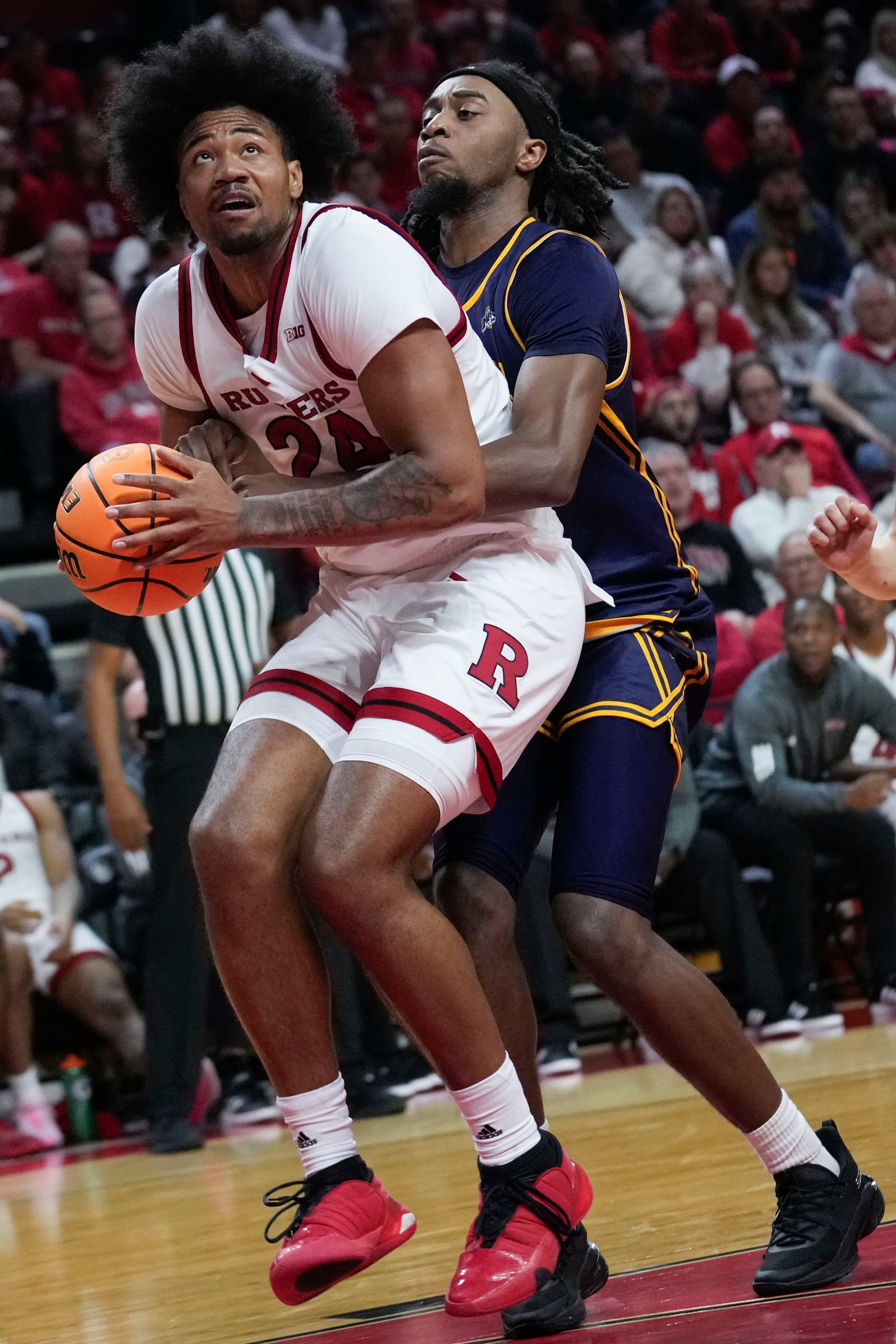 Rutgers' Lathan Sommerville (24), left, is fouled by Merrimack's Bryan Etumnu during the second half of an NCAA college basketball game Wednesday, Nov. 20, 2024, in Piscataway, N.J. Rutgers defeated Merrimack 74-63. (AP Photo/Seth Wenig)