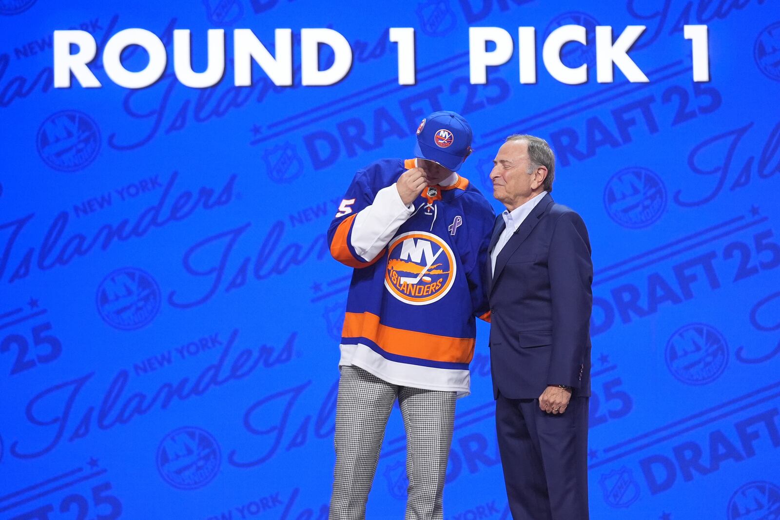 Matthew Schaefer, left, reacts with NHL commissioner Gary Bettman after being drafted by the New York Islanders during the NHL hockey draft Friday, June 27, 2025, in Los Angeles. (AP Photo/Damian Dovarganes)