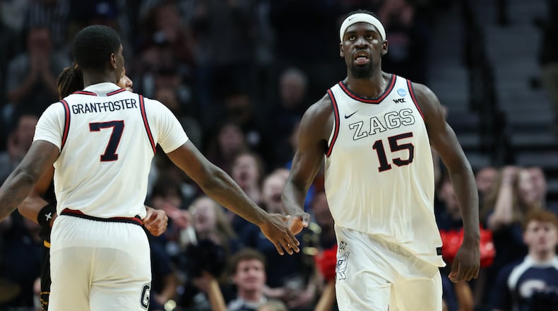 Gonzaga forward Graham Ike (15) reacts with guard Tyon Grant-Foster after a play during the second half in the first round of the NCAA college basketball tournament against Kennesaw State, Thursday, March 19, 2026, in Portland, Ore. (AP Photo/Amanda Loman)