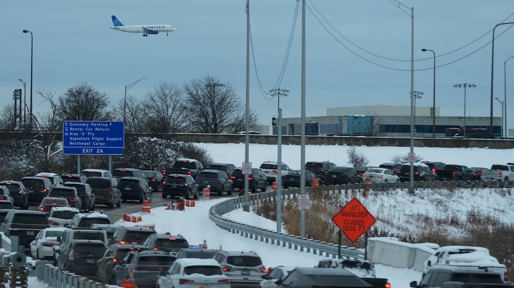 An United airplane descends to land at O'Hare International Airport as heavy traffic is seen on highway to airport in Chicago, Sunday, Nov. 30, 2025. (AP Photo/Nam Y. Huh)