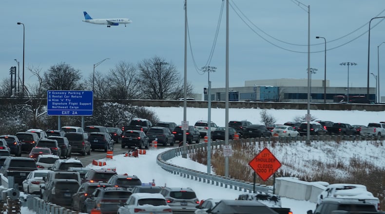 An United airplane descends to land at O'Hare International Airport as heavy traffic is seen on highway to airport in Chicago, Sunday, Nov. 30, 2025. (AP Photo/Nam Y. Huh)