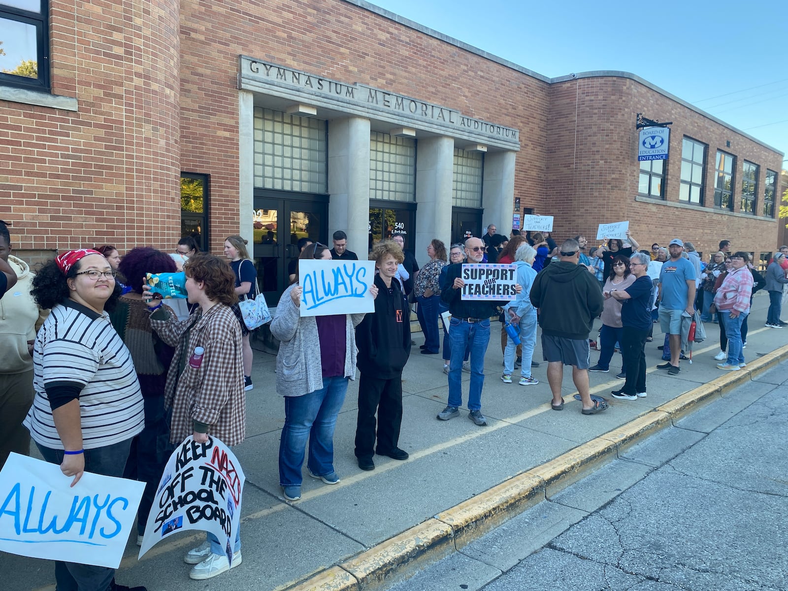 Miamisburg community members show their support for two teachers who previously were placed under paid administrative leave during a protest before the board meeting Thursday, Oct. 9, 2025. ERIC SCHWARTZBERG / STAFF
