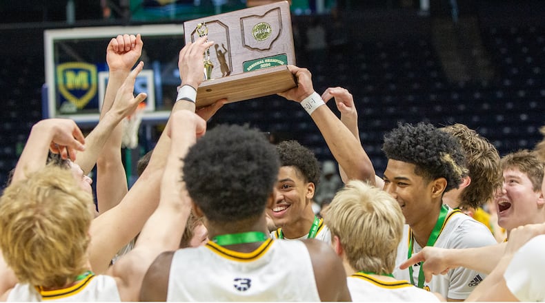Centerville's Jonathan Powell (center), Boubacarr Njie (right) and their teammates celebrate a fourth straight regional title, a 70-69 double overtime win over Cincinnati Moeller. Jeff Gilbert/CONTRIBUTED