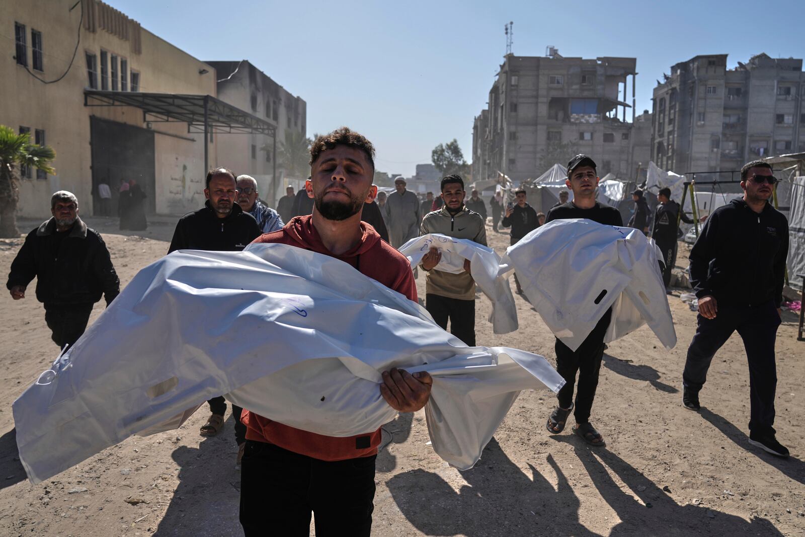 Mourners carry white sacks cover the bodies of members of the Abu Al-Rous family, killed when an Israeli airstrike struck their displacement tent overnight, during their funeral in Khan Younis, southern Gaza Strip, Thursday, April 17, 2025. (AP Photo/Abdel Kareem Hana)