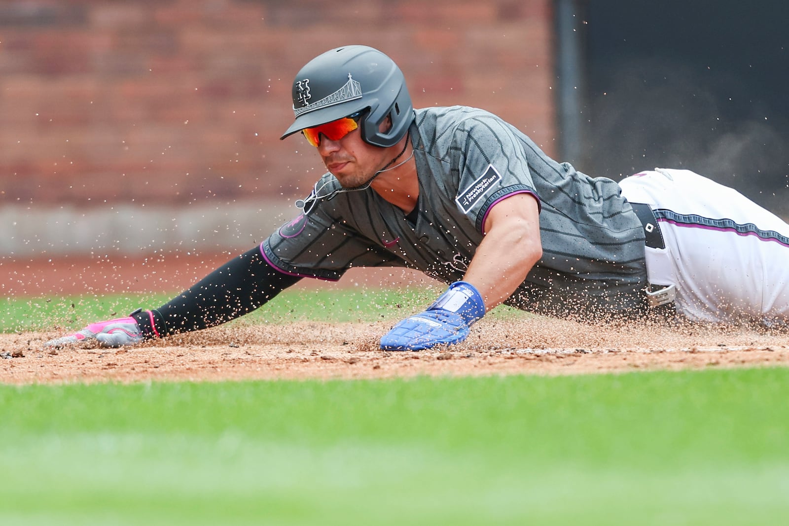 New York Mets' Tyrone Taylor slides home to score in the third inning of a baseball game against the Cincinnati Reds, Sunday, July 20, 2025, in New York. (AP Photo/Heather Khalifa)