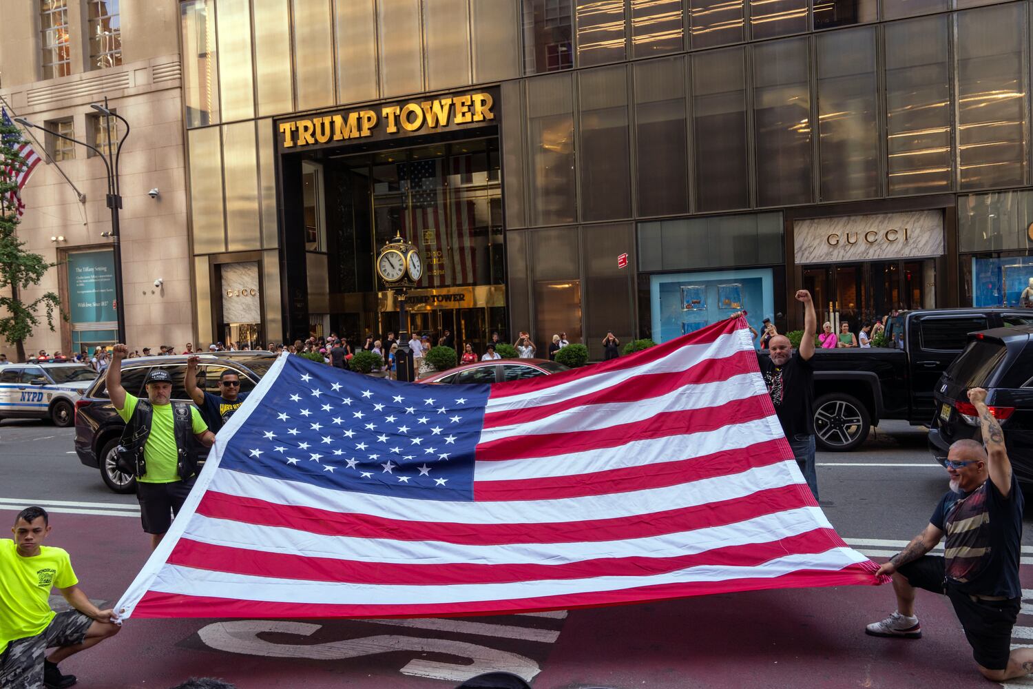 
                        Supporters of former President Donald Trump unfurl an oversized United States flag outside Trump Tower in midtown Manhattan on Sunday morning, July 14, 2024, one day after Trump was shot while speaking at a campaign rally in Butler, Pa. Trump was declared “fine” by his campaign, and the gunman was killed by Secret Service snipers. The explosion of political violence further inflamed the campaign for the White House.  (Adam Gray/The New York Times)
                      
