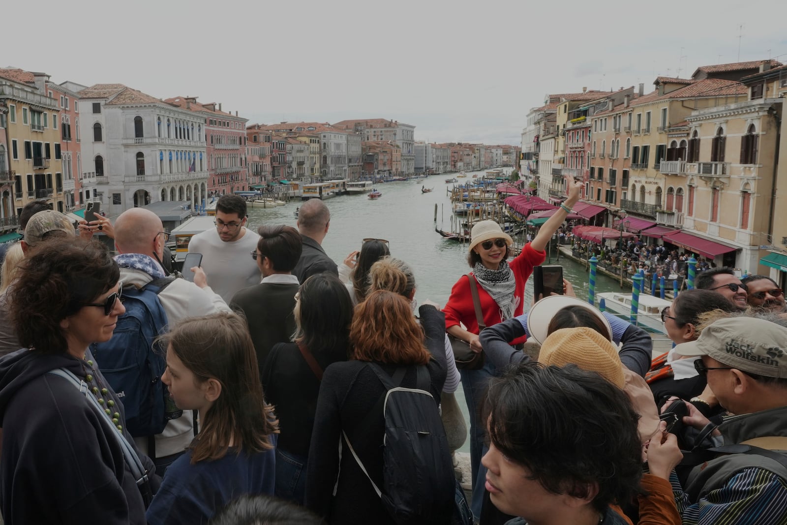 Tourists take pictures on Rialto Bridge "Ponte di Rialto" in Venice, Italy, Friday, April 18, 2025, Venice on Friday launches for a second year a pilot program to charge day-trippers an entrance fee. (AP Photo/Antonio Calanni)