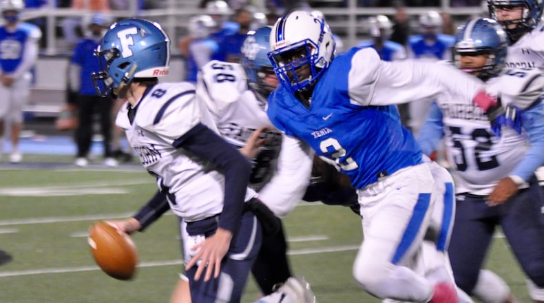 Xenia linebacker Johnzel Gray pursues Fairborn quarterback Garison Secrest during the Buccaneers’ 50-8 win against the Skyhawks at Doug Adams Stadium, Thursday night. Nick Dudukovich/CONTRIBUTED