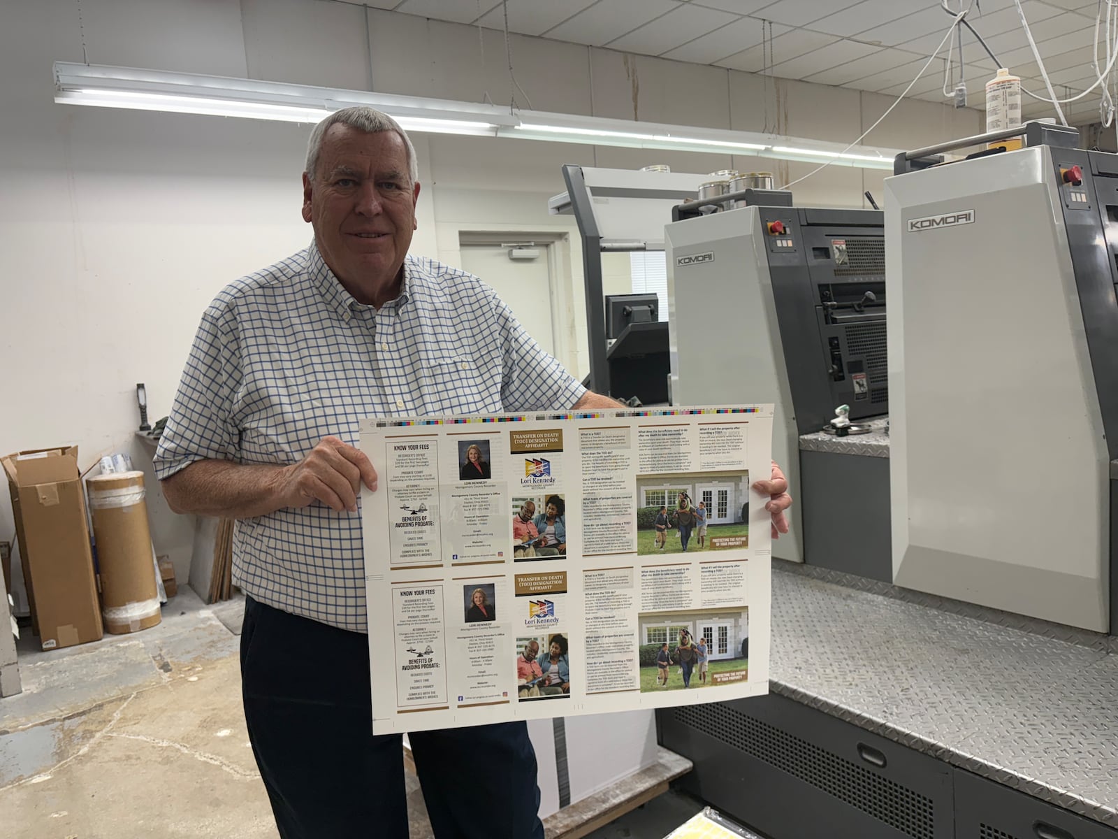 Denny Carter, co-founder of Creative Impressions in Kettering, is shown Friday, Aug. 29, 2025, holding what will become two trifold brochures about services provided by the Montgomery County Recorder's Office. JEN BALDUF/STAFF