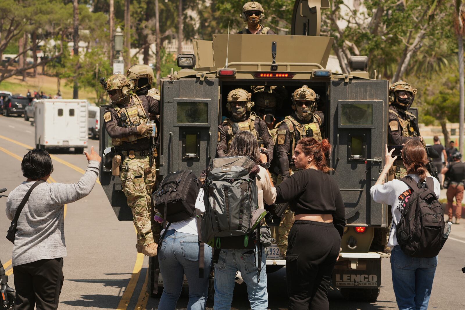 Federal agents ride on and armored vehicle at MacArthur Park Monday, July 7, 2025, in Los Angeles. (AP Photo/Damian Dovarganes)