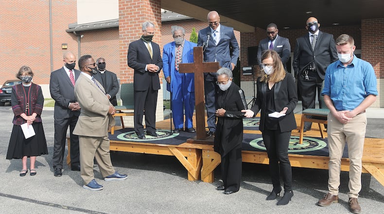 Members of the Dayton Ministers United for Social Change (DMUSC) bow their heads in pray at the St. Luke Missionary Bastist Church Monday after making a public statement denouncing racial injustice. MARSHALL GORBY\STAFF