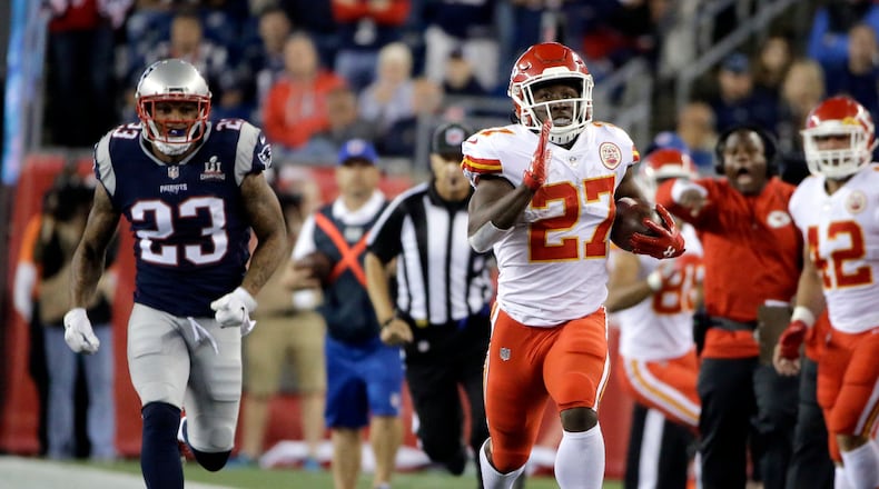 Kansas City Chiefs running back Kareem Hunt (27) runs from New England Patriots safety Patrick Chung (23) during the second half of an NFL football game, Friday, Sept. 8, 2017, in Foxborough, Mass. (AP Photo/Steven Senne)