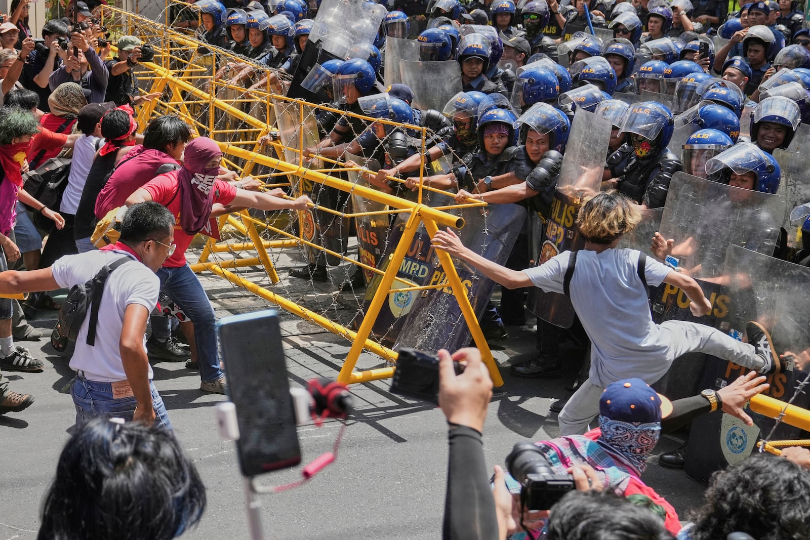 Activists and workers scuffle briefly with police as they tried to remove the barricades during a May Day rally near the Malacanang presidential palace in Manila, Philippines on Thursday, May 1, 2025. (AP Photo/Aaron Favila)