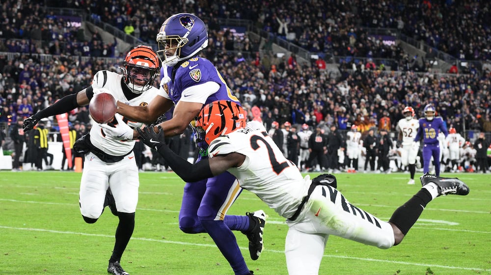 Baltimore Ravens tight end Isaiah Likely, center, looses control of the ball before the end zone as Cincinnati Bengals cornerback Jalen Davis, left, and safety Jordan Battle, right, move in on the play during the first half of an NFL football game, Thursday, Nov. 27, 2025, in Baltimore. (AP Photo/Nick Wass)