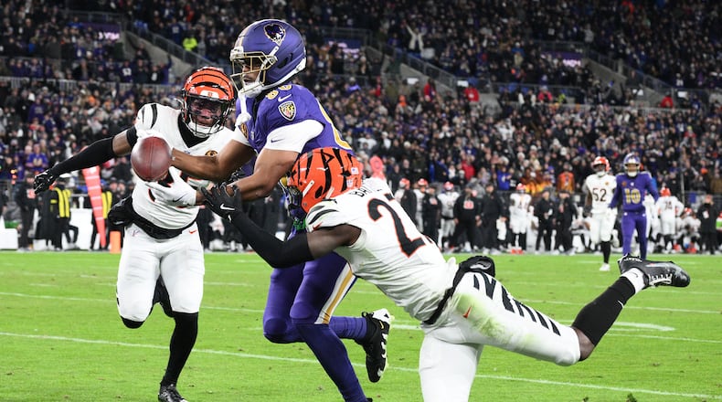 Baltimore Ravens tight end Isaiah Likely, center, looses control of the ball before the end zone as Cincinnati Bengals cornerback Jalen Davis, left, and safety Jordan Battle, right, move in on the play during the first half of an NFL football game, Thursday, Nov. 27, 2025, in Baltimore. (AP Photo/Nick Wass)