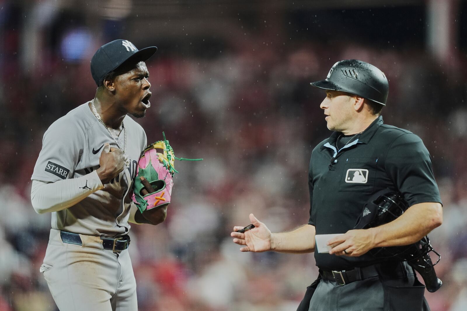 New York Yankees' Jazz Chisholm Jr., left, confronts home plate umpire Mark Wegner, right, while taking the field after being called out on strikes during the ninth inning of a baseball game against the Cincinnati Reds, Tuesday, June 24, 2025, in Cincinnati. (AP Photo/Joshua A. Bickel)