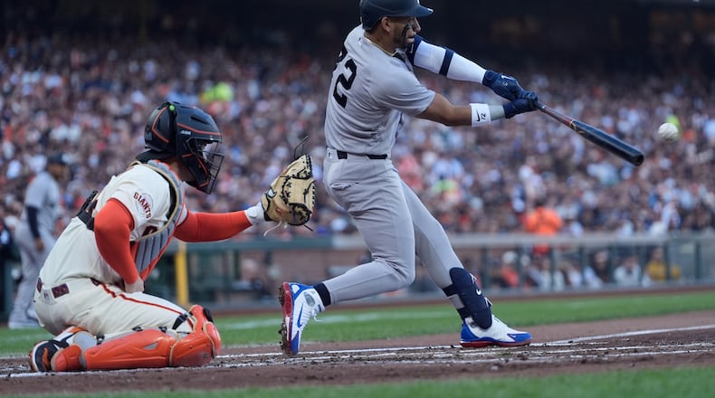 New York Yankees' José Caballero, right, hits an RBI double in front of San Francisco Giants catcher Patrick Bailey, left, during the second inning of a baseball game in San Francisco, Wednesday, March 25, 2026. (AP Photo/Jeff Chiu)
