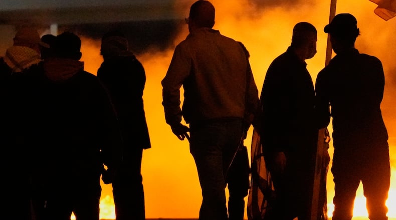 Security forces fire tear gas to disperse a protest against U.S. and Israeli attacks on Iran, at a bridge leading to the fortified Green Zone where the U.S. Embassy is located in Baghdad, Sunday, March 1, 2026. (AP Photo/Hadi Mizban)
