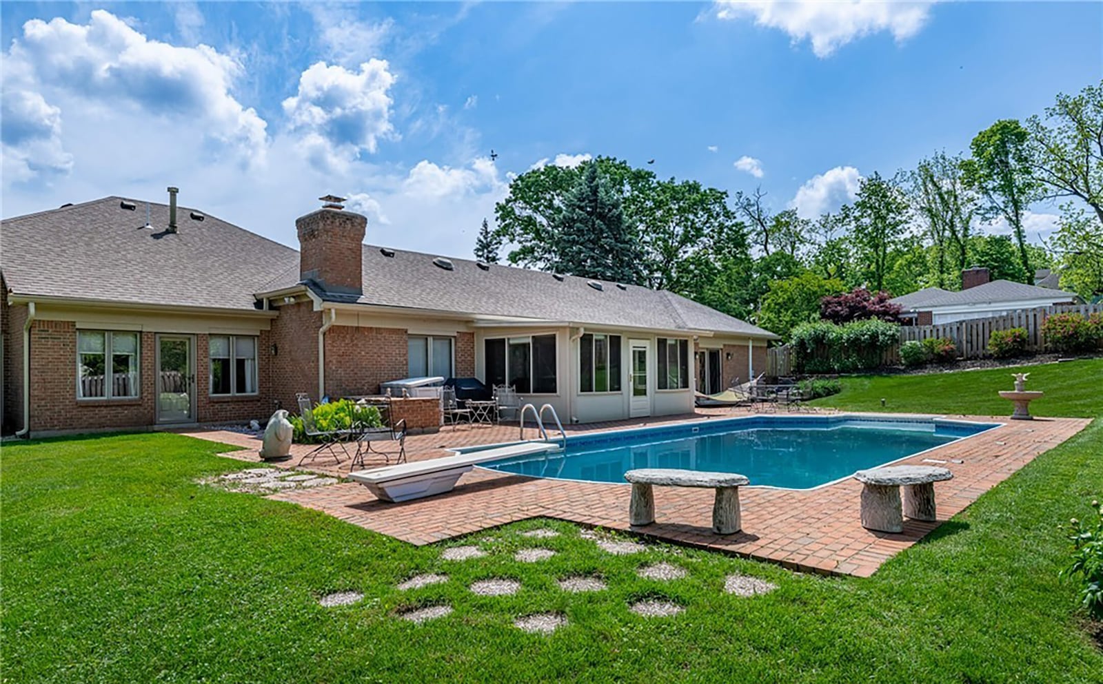 The back yard is fully fenced and has an inground pool with diving board and ladder. It is surrounded by a brick paver patio and has built in stone benches. CONTRIBUTED