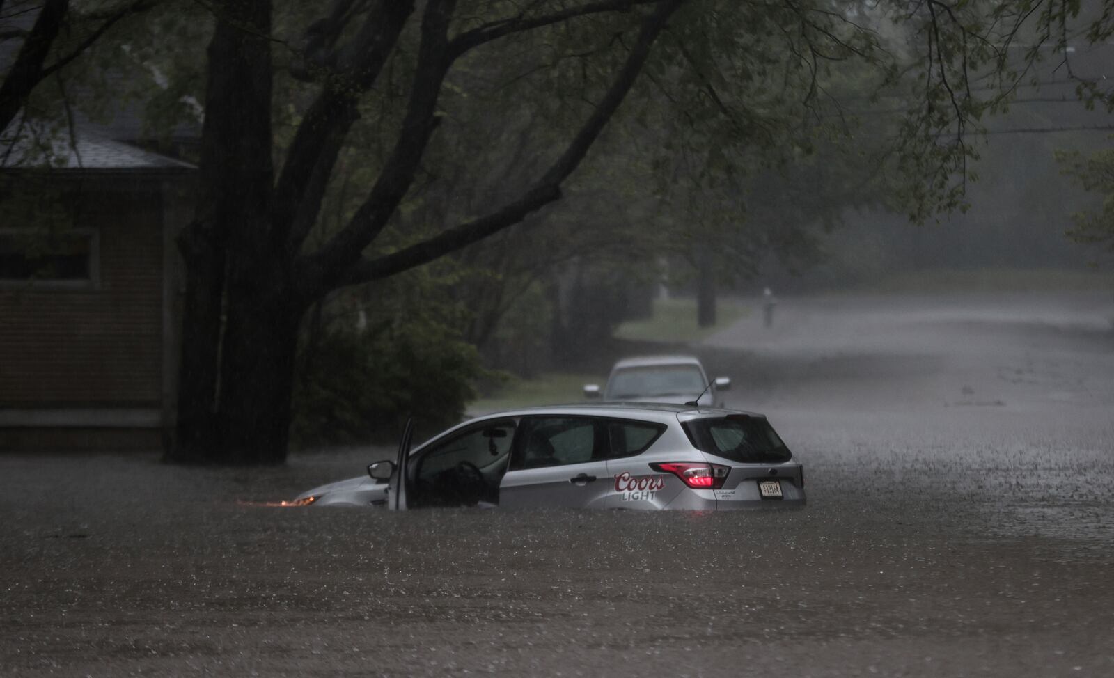 A car is stuck in floodwaters near the corner of Cowden Street and Tanglewood Avenue as heavy rain falls, Saturday, April 5, 2025, in Memphis, Tenn. (Patrick Lantrip/Daily Memphian via AP)