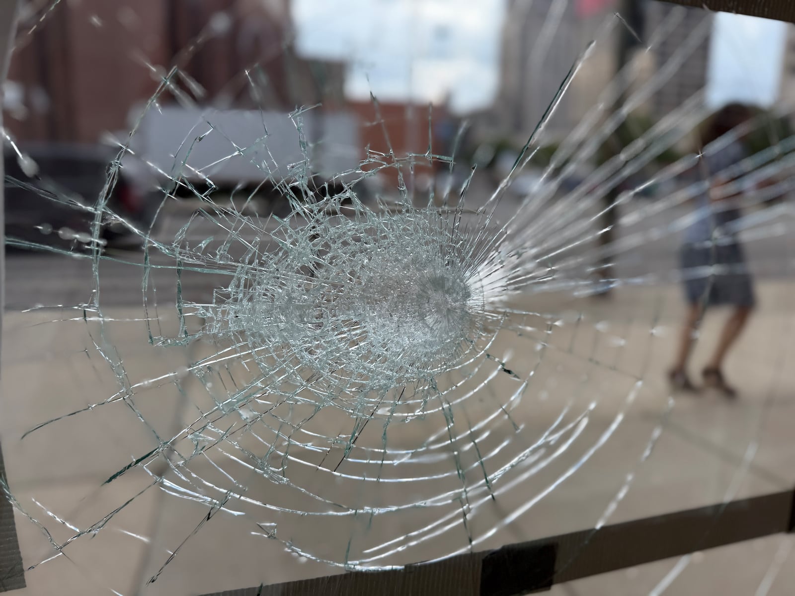 A broken window at Rabbit Hole Books at 29 W. First Street in the northwest part of downtown Dayton. Someone damaged windows and doors of at least six businesses and storefronts on Aug. 12, 2025. CORNELIUS FROLIK / STAFF