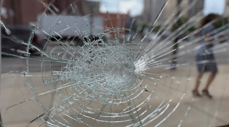 A broken window at Rabbit Hole Books at 29 W. First Street in the northwest part of downtown Dayton. Someone damaged windows and doors of at least six businesses and storefronts on Aug. 12, 2025. CORNELIUS FROLIK / STAFF