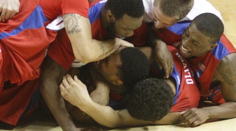 Dayton players celebrate after a 60-59 victory against Ohio State in the second round of the NCAA tournament on Thursday, March 20, 2014, at the First Niagara Center in Buffalo, N.Y. David Jablonski/Staff