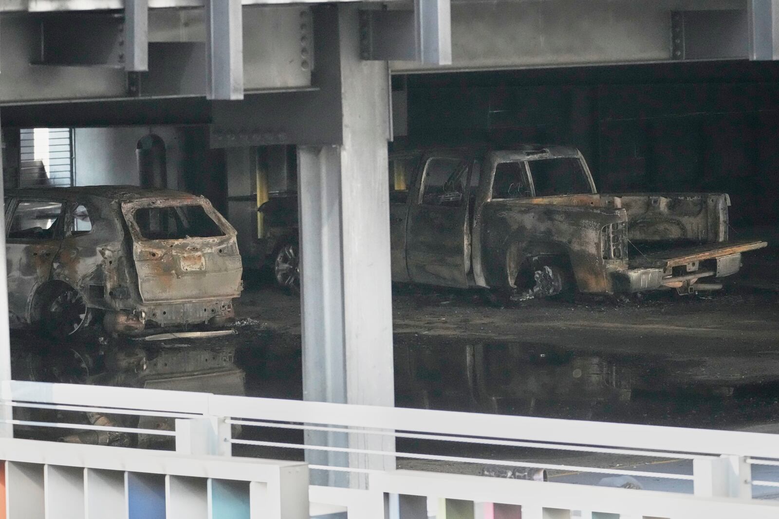 Burned vehicles are seen inside a garage that caught fire and a floor of the structure collapsed Tuesday, June 10, 2025, in Nashville, Tenn. (AP Photo/George Walker IV)