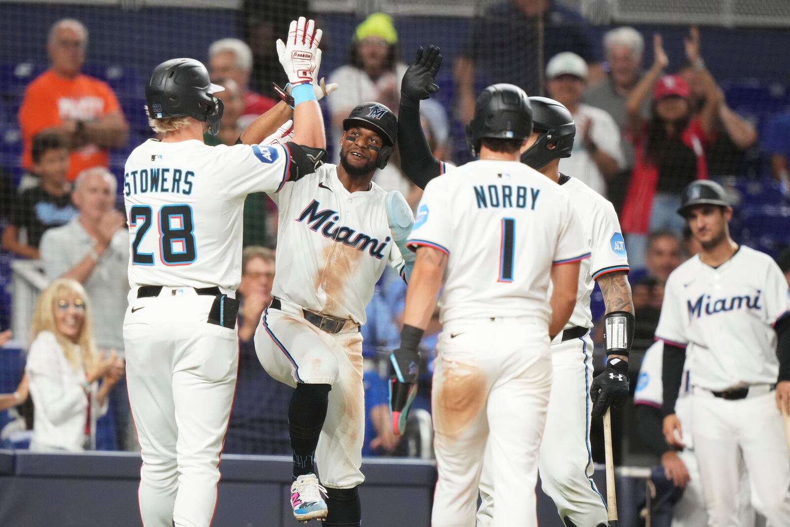 Miami Marlins' Kyle Stowers (28) is met by second baseman Otto Lopez, second from left, after hitting a three run home run during the seventh inning of a baseball game against the Cincinnati Reds, Monday, April 21, 2025, in Miami. (AP Photo/Lynne Sladky)