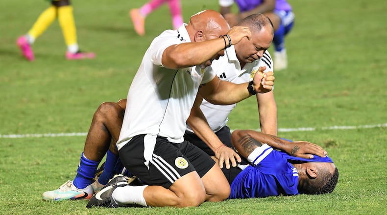 Curacao players and trainers celebrate qualifying for the 2026 FIFA World Cup after their game with Jamaica in Kingston, Jamaica, Tuesday, Nov. 18, 2025. (AP Photo/Collin Reid)