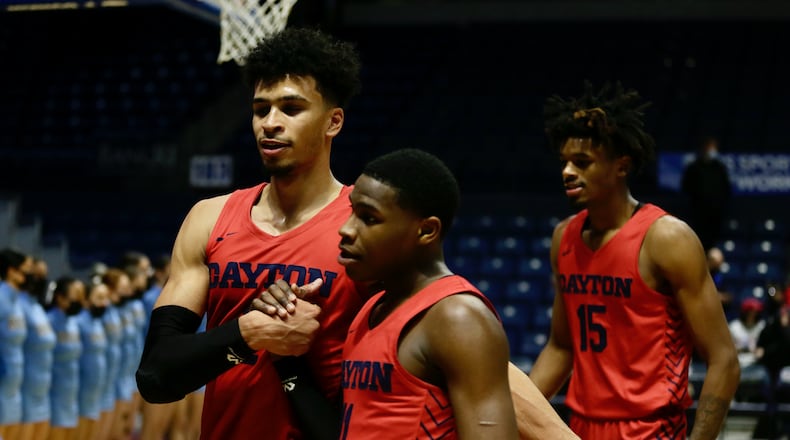 Dayton's Toumani Camara, left, and Malachi Smith, center, leave the court after a victory against Rhode Island on Monday, Feb. 14, 2022, at the Ryan Center in Kingston, R.I. David Jablonski/Staff